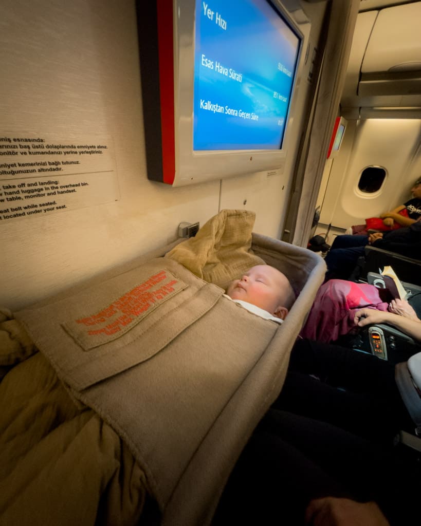 Baby in a baby bassinet on plane