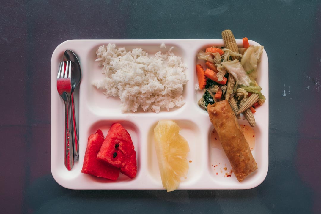 The tray of food from our tour with rice, vegetables, a spring roll and fruit