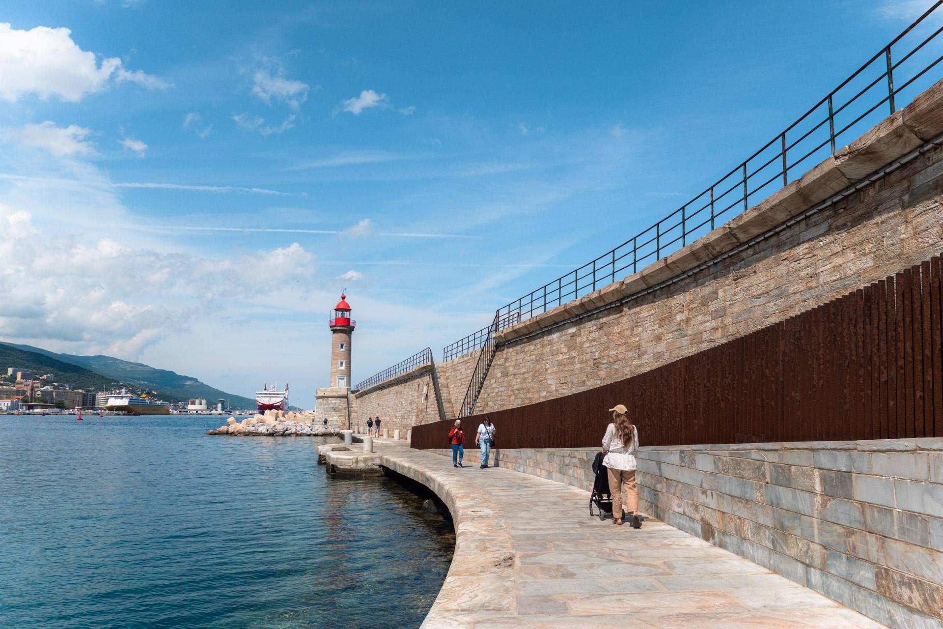Red lighthouse at the end of the harbour wall