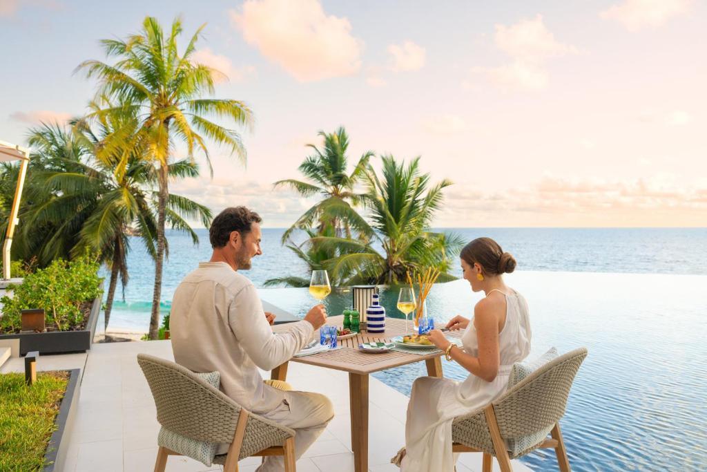 Couples enjoying wine by the pool at Cheval Blanc Seychelles