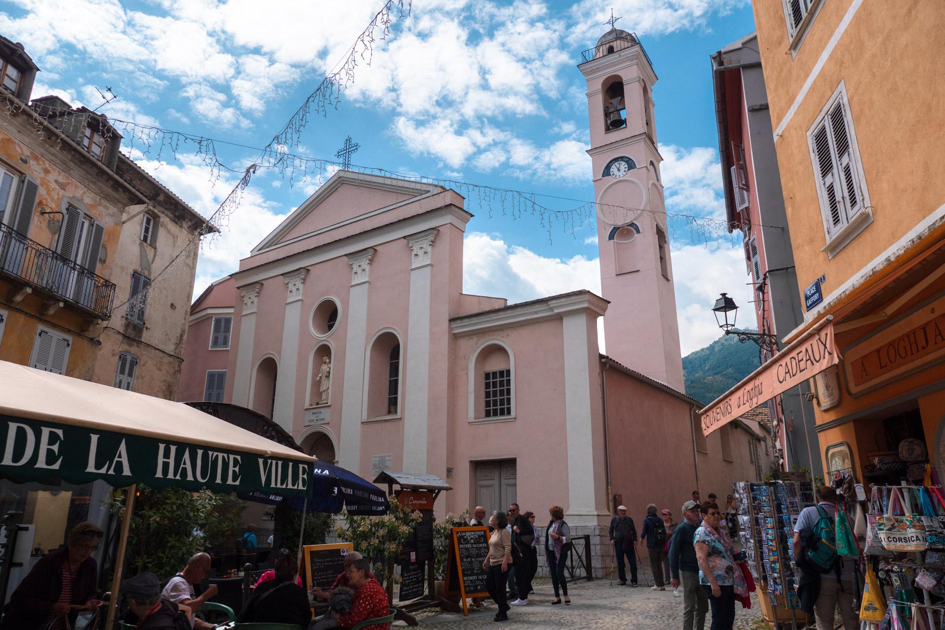 The pink Church of the Annunciation stands out brightly against the blue sky