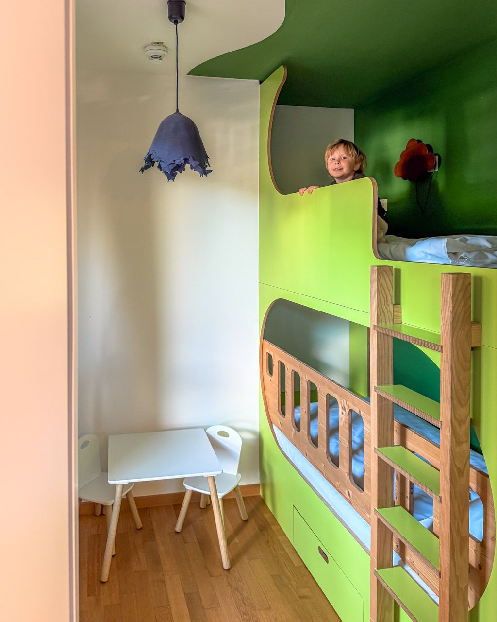 Adrian peeking over the edge of the top bunk in the children's room at Leiners