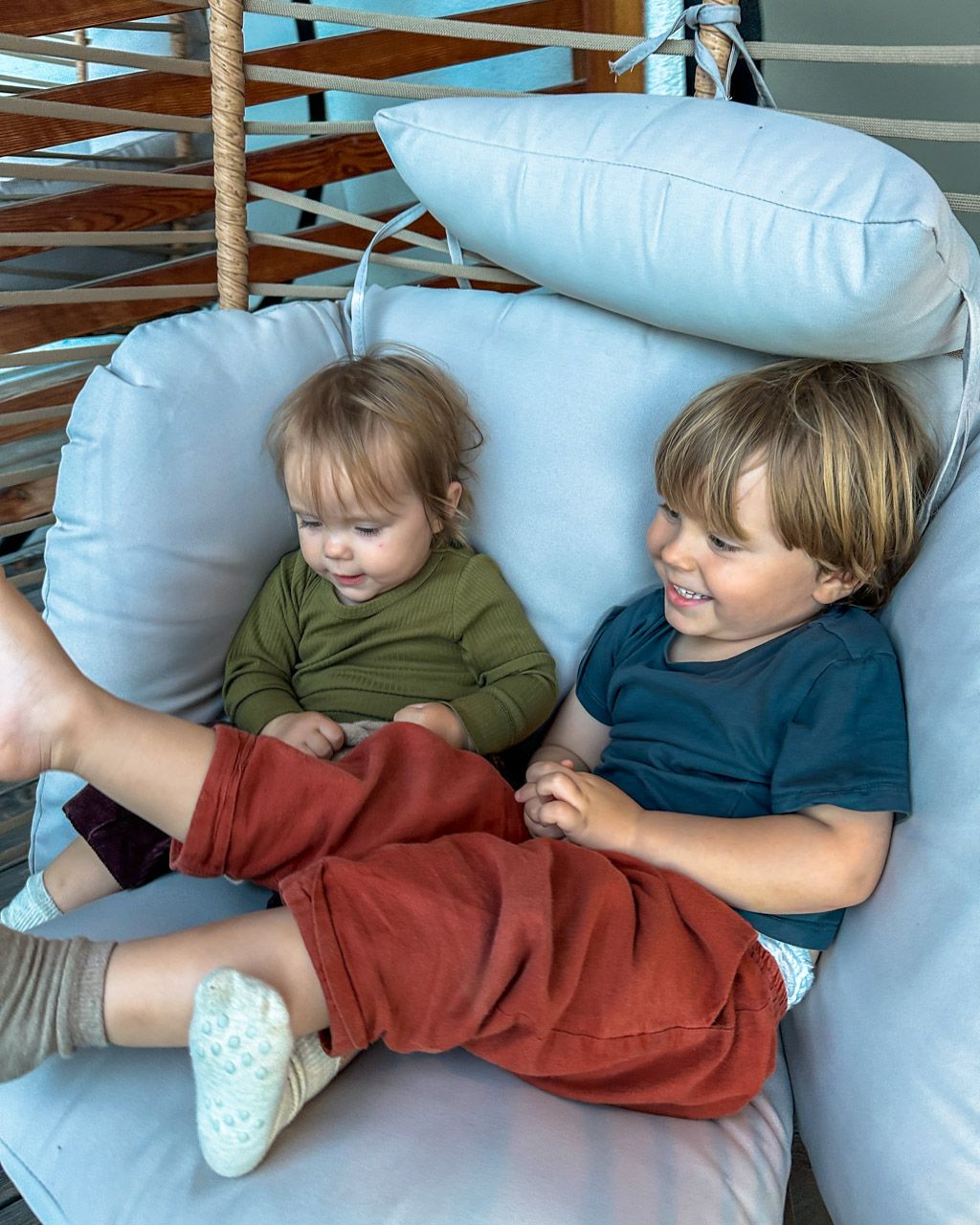 Zoe and Adrian sharing the hanging egg chair on the balcony at Leiners