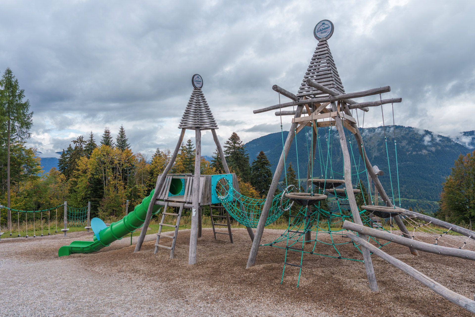Wooden playground towers with Eckbauerbahn logos at the Eckbauer summit playground