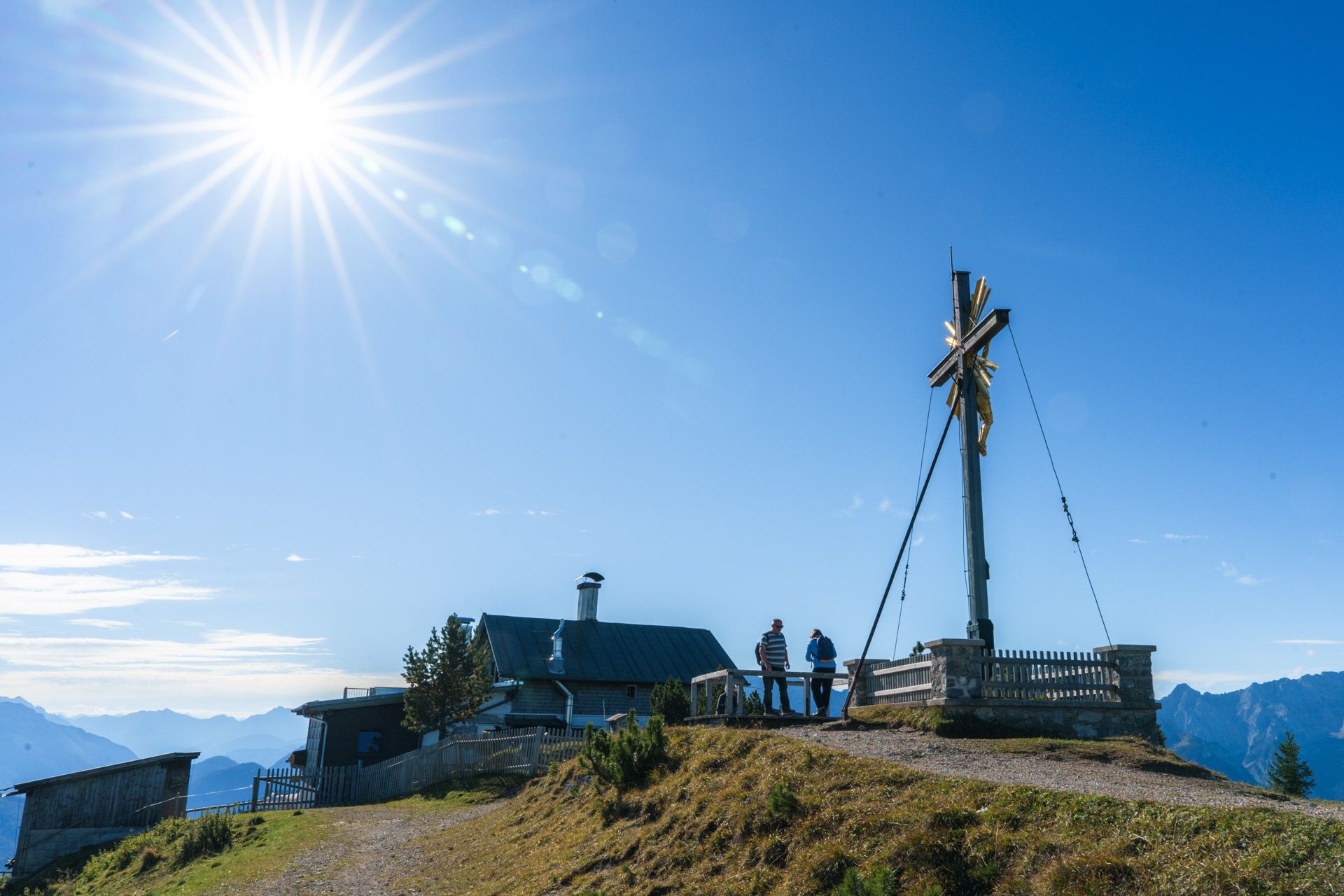 Summit cross at Wank with mountain hut behind