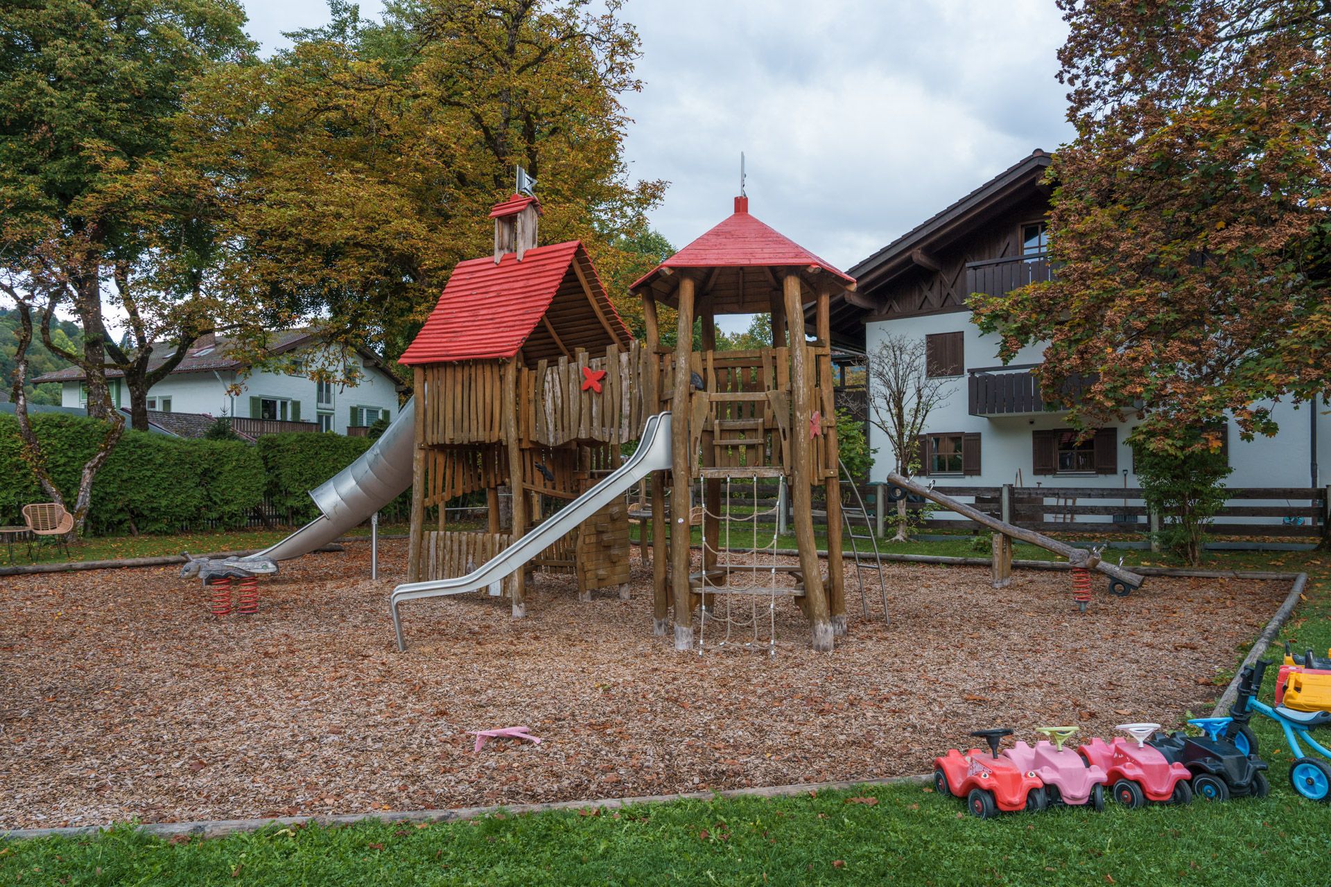 Wooden playground tower with a red roof and metal slide at Leiners