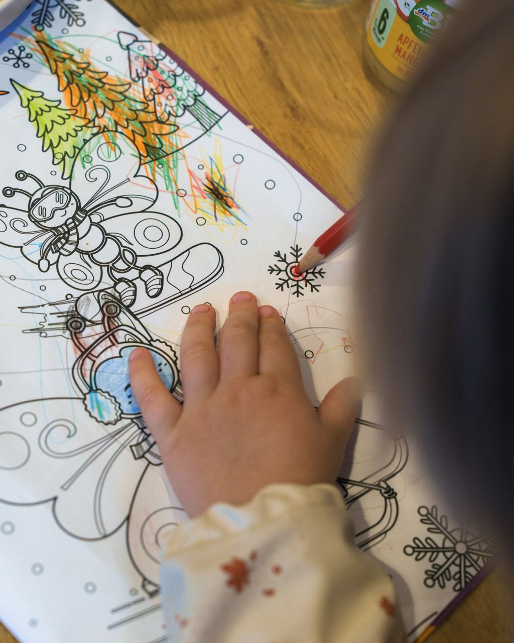Child colouring in the Leiners colouring book at the restaurant table