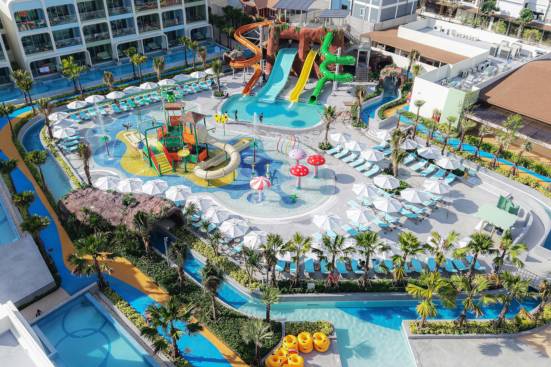Aerial view of Katathani Phuket resort pool complex with colorful waterslides, children's play area, loungers, and palm trees.
