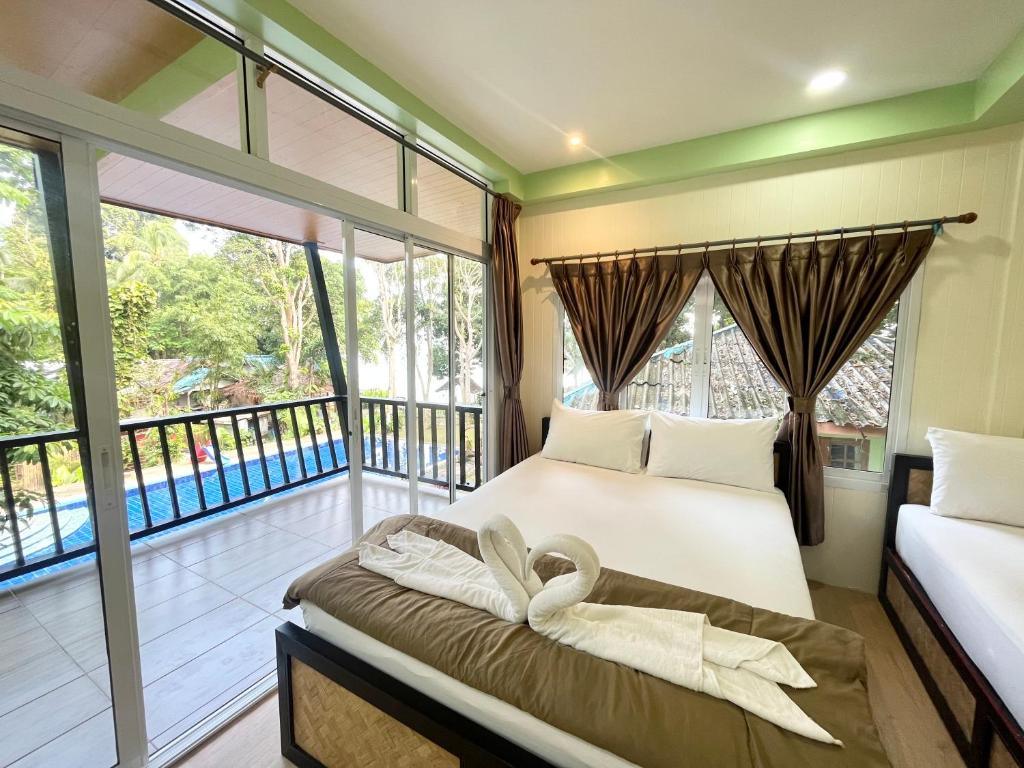 Interior of a villa at Koh Mook Garden Beach Resort with wooden finishes and a large bed.