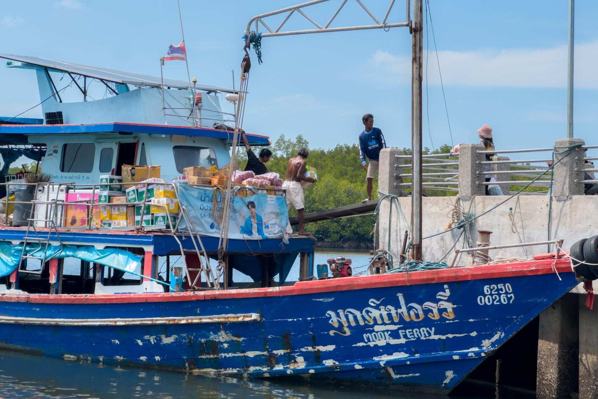 Thai ferry docked at Kuan Tung Ku Pier with crew loading cargo and Thai flag flying overhead.