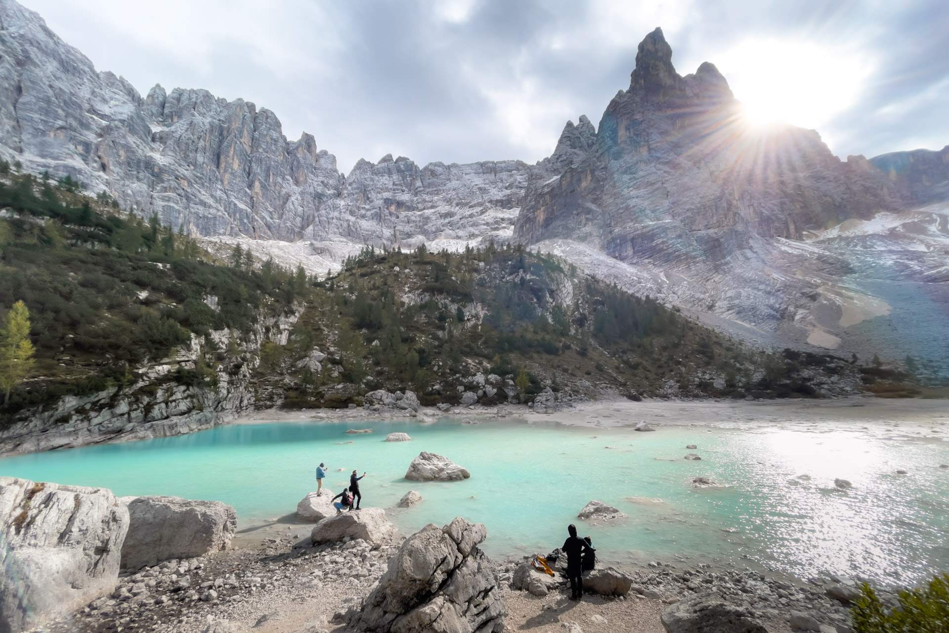 People on rocks in front of Lago di Sorapis with Dito di Dio (Finger of God)