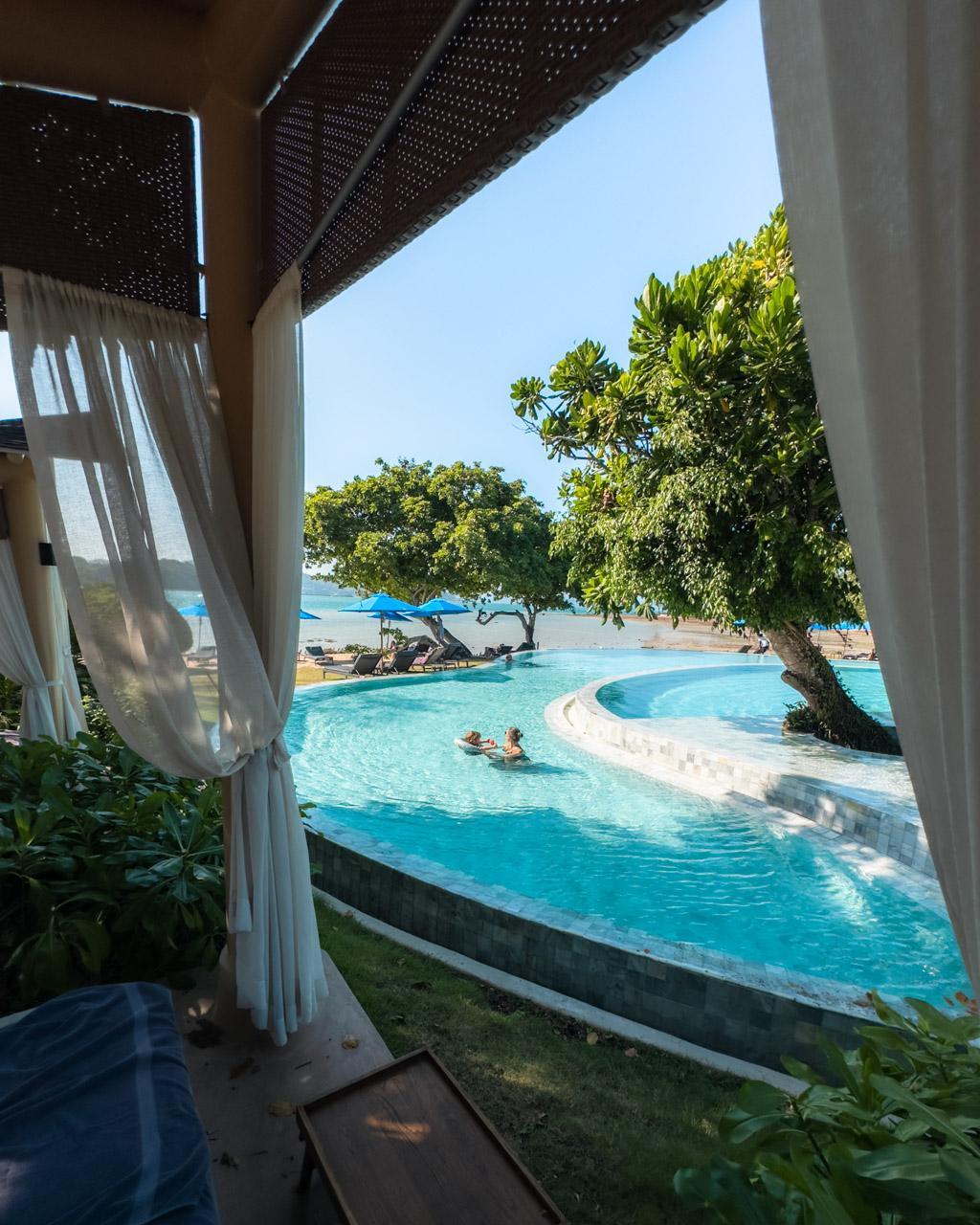 Victoria and Adrian in the pool seen through a pool sala