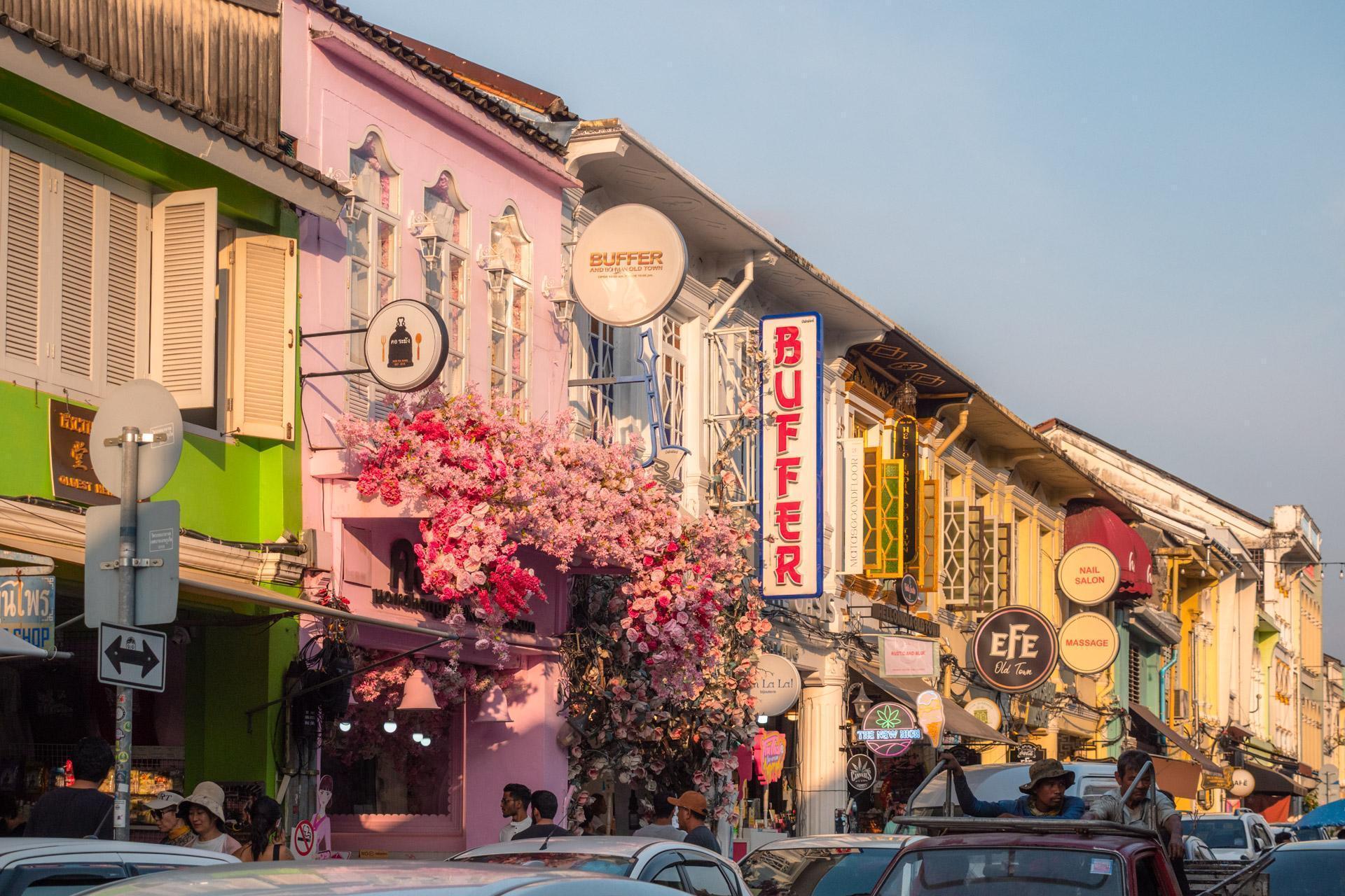Thalang Road in the sunset with cars and shop signs