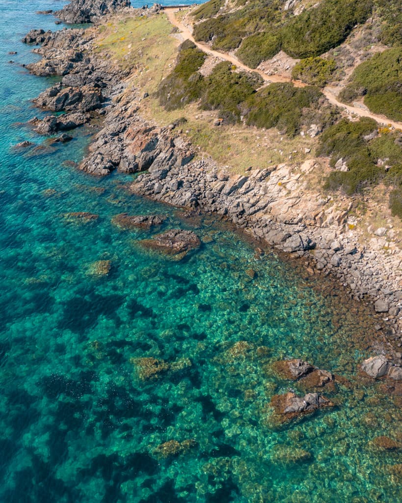 The dramatic rocky coastline meets crystal-clear water.