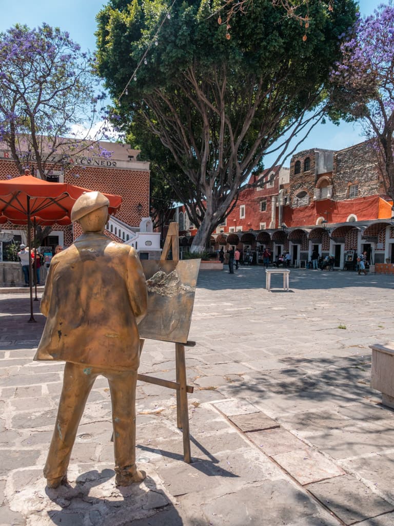 A golden statue of an artist and his easel in Puebla