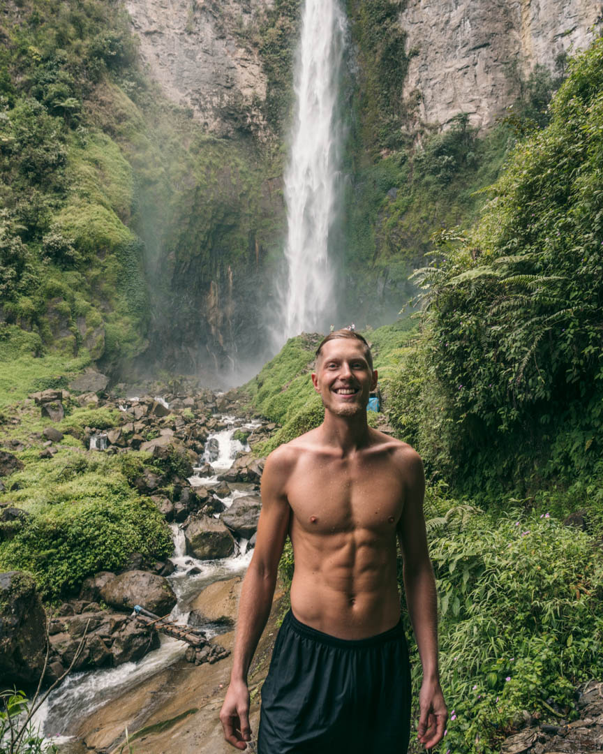 Alex in front of the base of Sipiso Waterfall