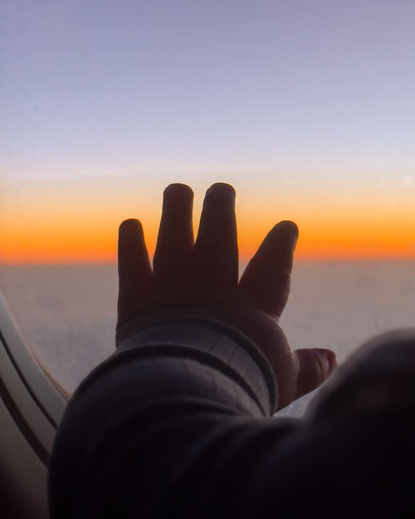 Adrian's hand on the window of the plane